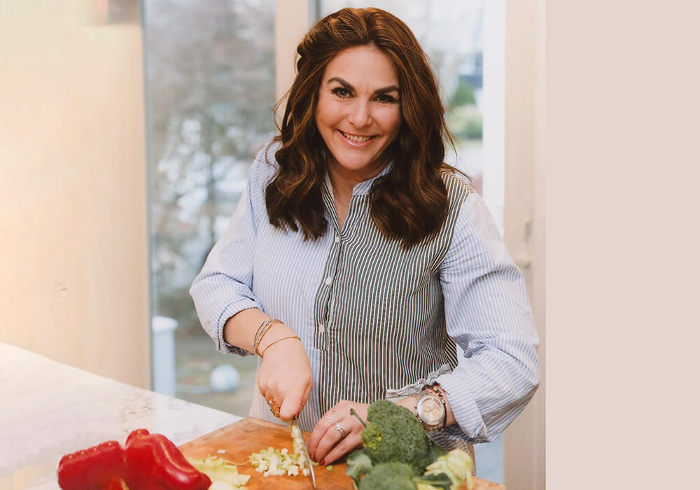 Naomi Nachman at cutting board chopping vegetables