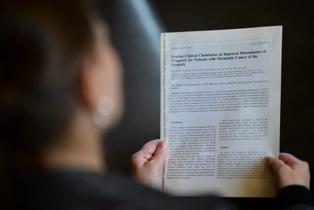 Jody Storch Green holding her article Routine Clinical Chemistries as Improved Determined Prognosis for Patients with Metastatic Cancer of the Stomach