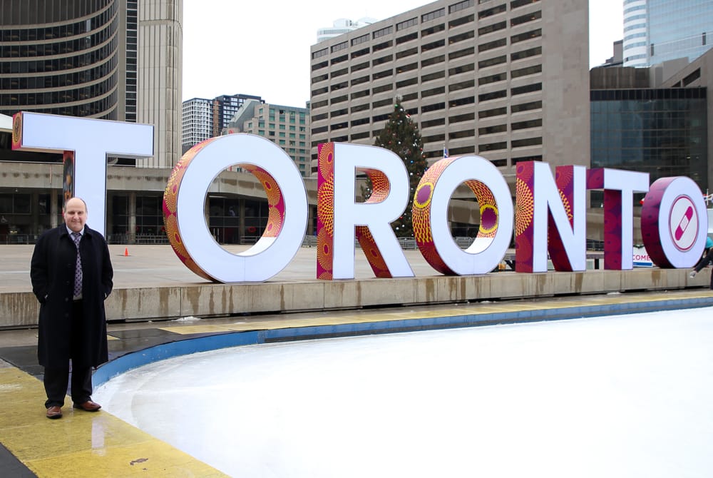 Maurice Benzaquen standing next to iconic Toronto sign