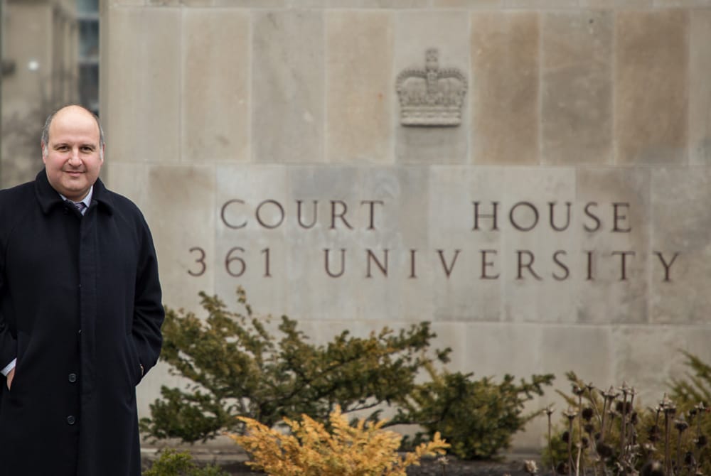 Maurice Benzaquen standing outside of Toronto court house sign