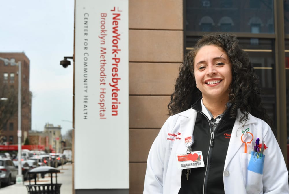 Georgia Van Cooten posing in front of Brooklyn Methodist hospital