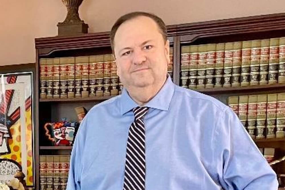 Todd J. Zimmer, Esq. standing in front of bookshelf